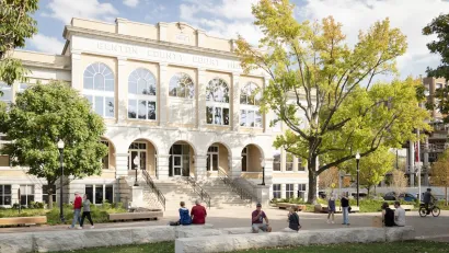 People sitting and walking in plaza in front of historic Benton County Courthouse in Bentonville, Arkansas.