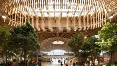 Indoor view of PDX's new massive airport terminal with a wooden beamed roof and skylight.