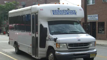 White 'dollar van' commuter transit minibus in New York City.