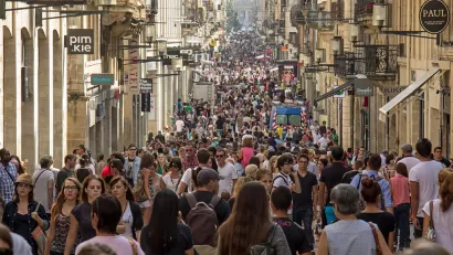 The Rue Sainte-Catherine in Bordeaux is crowded with pedestrians in a lively European scene.