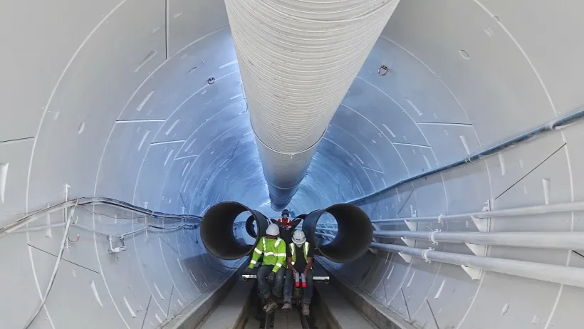 Two workers inside white Boring Company tunnel in Hawthorne, California.