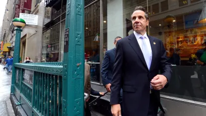 Former New York Governor Andrew Cuomo walking down city street.