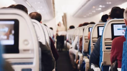 Airplane aisle with seated passengers
