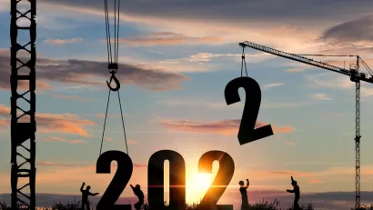 A silhouette of construction workers lowering larger numerals into place to form 2022.