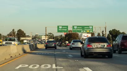 Smog hovers in the air in the background of this image of heavy car traffic on the 405 Freeway near ints intersection with the 710 Freeway in Southern California.