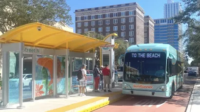 Blue SunRunner bus in Tampa Bay at station with dedicated bus lane, marquee reads "To the beach."
