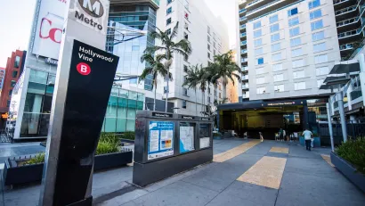 Entrance to subterranean Hollywood/Vine Metro station in Los Angeles, California surrounded by tall apartment buildings.