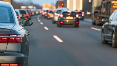 Close-up of rear car bumper in traffic on freeway.