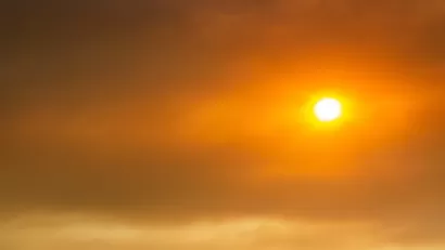 Sun seen through red wildfire sky and smoke.