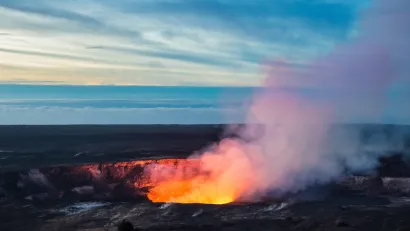 Lava visible in crater with steam coming out in Hawaii.