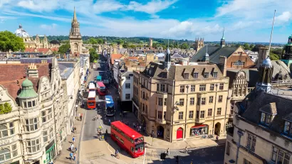 Aerial view of historic Oxford, England street with old buildings and red double-decker bus