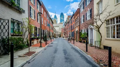 Street with old buildings in Philadelphia, Pennsylvania and modern high-rise buildings in background.