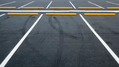 Empty asphalt parking lot with white lines.