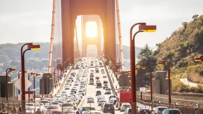View of traffic on Golden Gate Bridge at sunset.
