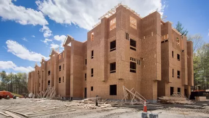 Wood-framed four-story building under construction.