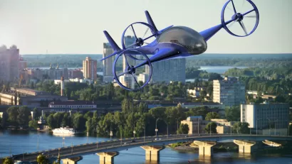 3D rendering of blue flying car over a cityscape and buildings, a river, and bridges in the background.