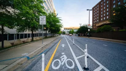 Bike lane protected by plastic delineators on street in downtown Baltimore, Maryland.