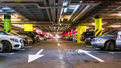 Interior of large parking garage full of cars.