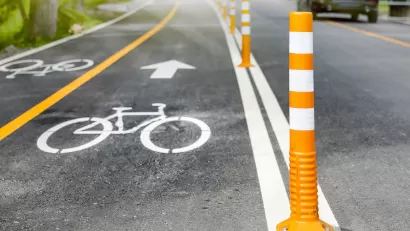 Bike lane delineated with white paint and orange bollards.