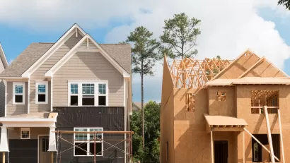 Two wood-frame houses under construction.