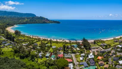Aerial view of coastal development and bright blue ocean in Kaua'i, Hawai'i.