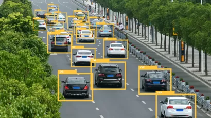 View of traffic on a multilane highway with superimposed yellow triangles identifying vehicles.