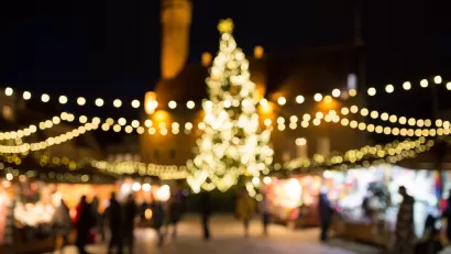 Blurred image of Christmas lights at nighttime draped over Christmas market in Tallin, Estonia.