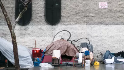 Tent covered with tarp with bike and other objects on sidewalk in Skid Row, downtown Los Angeles
