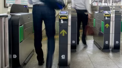 People entering modern fare gates in subway station.