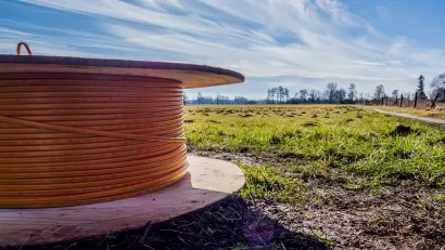 Close-up of spool of broadband internet wire sitting on the ground