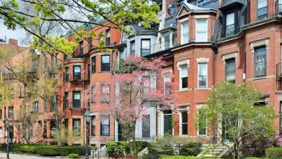 Brick brownstone homes in Back Bay, Boston with green hedges in front.