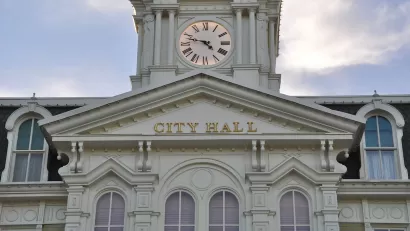 White neoclassical building with cupola and City Hall lettering on front.