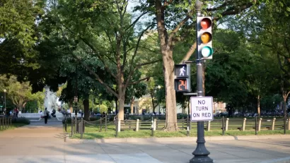 "No turn on red" sign on signpost with pedestrian stoplight.