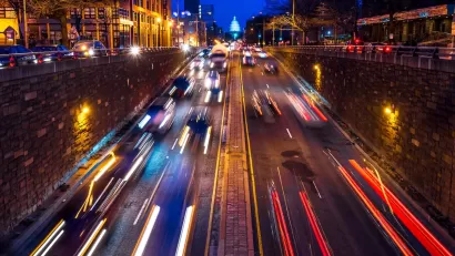 Nighttime view of blurred fast car traffic on street leading to U.S. Capitol dome in Washington, D.C.