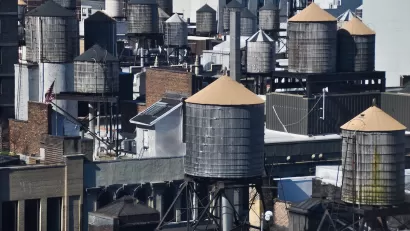 Old water towers on dense New York City rooftops.