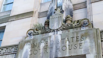Close-up of carved United States Court House sign with eagle seal above a doorway.