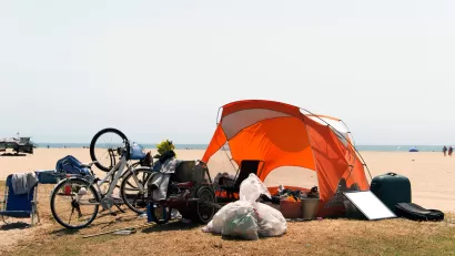 Orange tent and bicycles belonging to unhoused people at Venice Beach, California