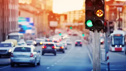 Traffic light with blurred cars and streetcar in background.