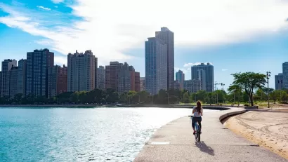Cyclist riding along paved path at edge of Lake Michigan in Chicago, Illinois.