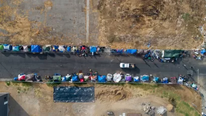 Aerial bird's eye view of unhoused encampment along roadside in Sacramento, California.