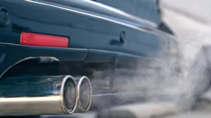 Close-up of car tailpipe emitting white smoke