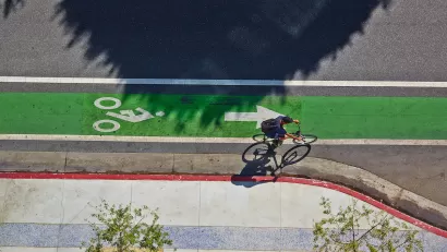 Bird's eye view of green painted bike lane with one cyclist.