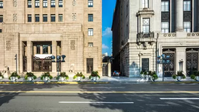 View from street of two neoclassical buildings with narrow alley between them.