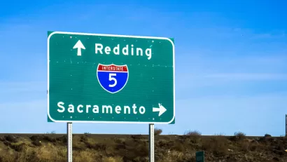 Close-up of green Interstate 5 freeway sign pointing to Redding and Sacramento.