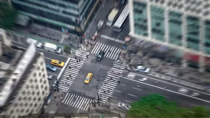 Aerial view of intersection in New York City with yellow cabs and zebra crosswalks.
