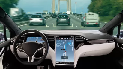 Interior of autonomous car with large map screen on road.