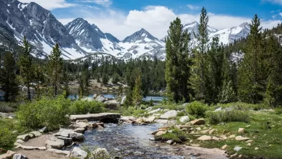 Small mountain lake with snow-capped mountains in background in Eastern Sierra Nevada mountains in California.