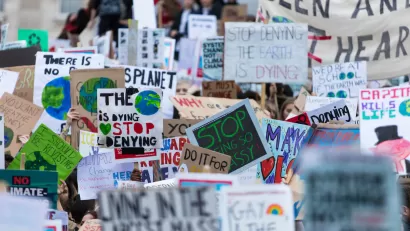 Close-up on dozens of anti-climate change signs at protest with people not visible.