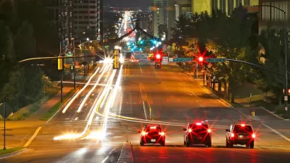 Three cars stopped at a traffic light in downtown Salt Lake City, Utah at night.