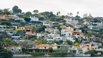 Dense neighborhood of homes on a hillside on the water in San Diego, California.
